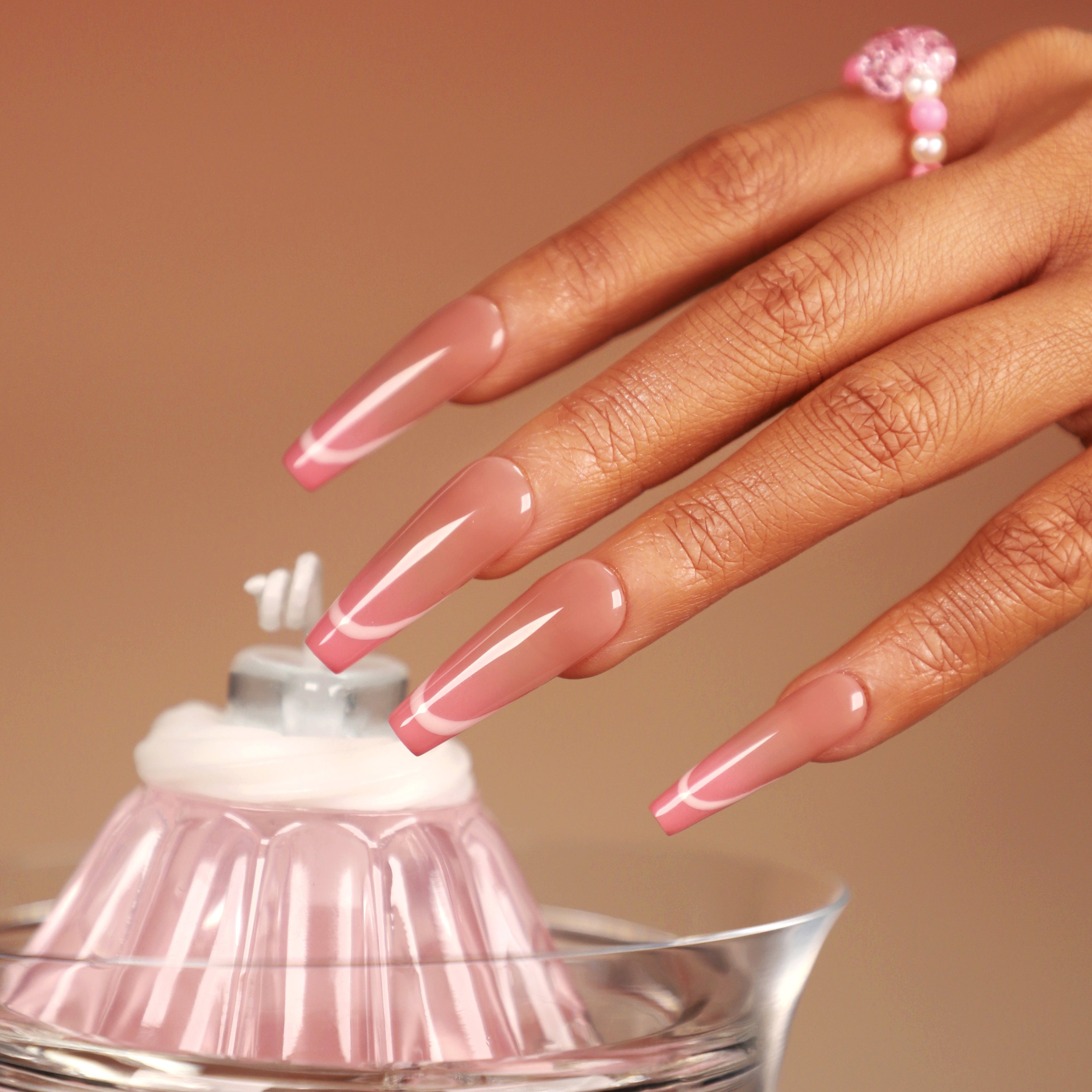 Neon pink outline press on nails with soft nude base, long glossy shape, reusable salon-quality false nails.