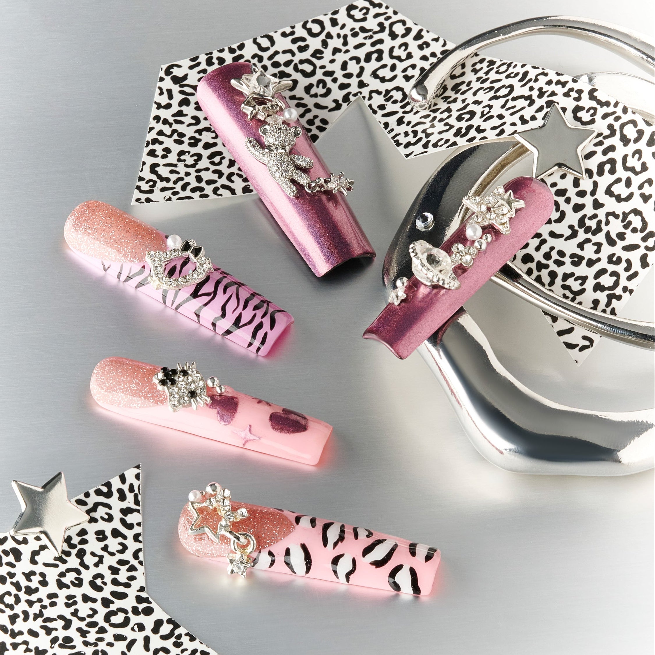 Violet pink crystal press on nails with metallic purple sheen, glitter half-moon design and star/planet charms.