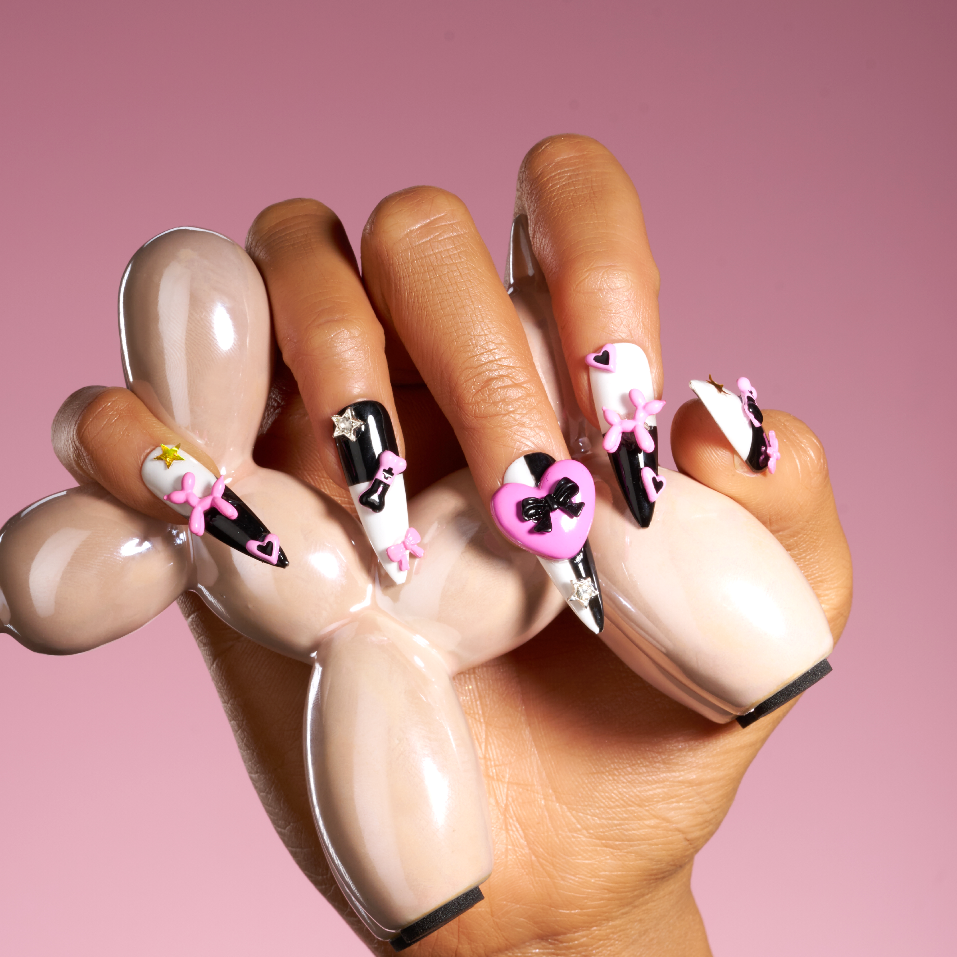 Bold black and white stiletto press on nails with 3D heart accents. Reusable statement nail set.