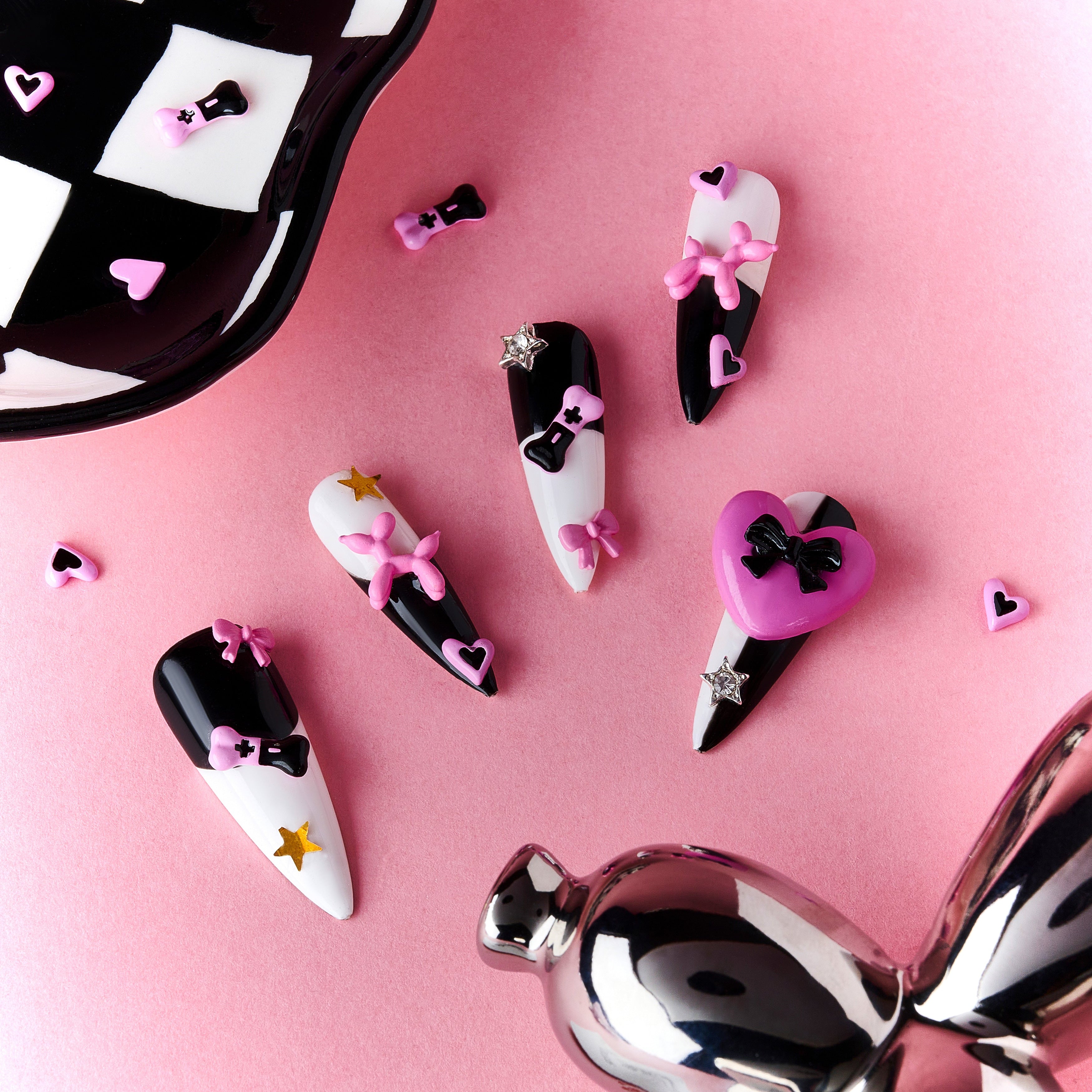 Bold black and white stiletto press on nails with 3D heart accents. Reusable statement nail set.