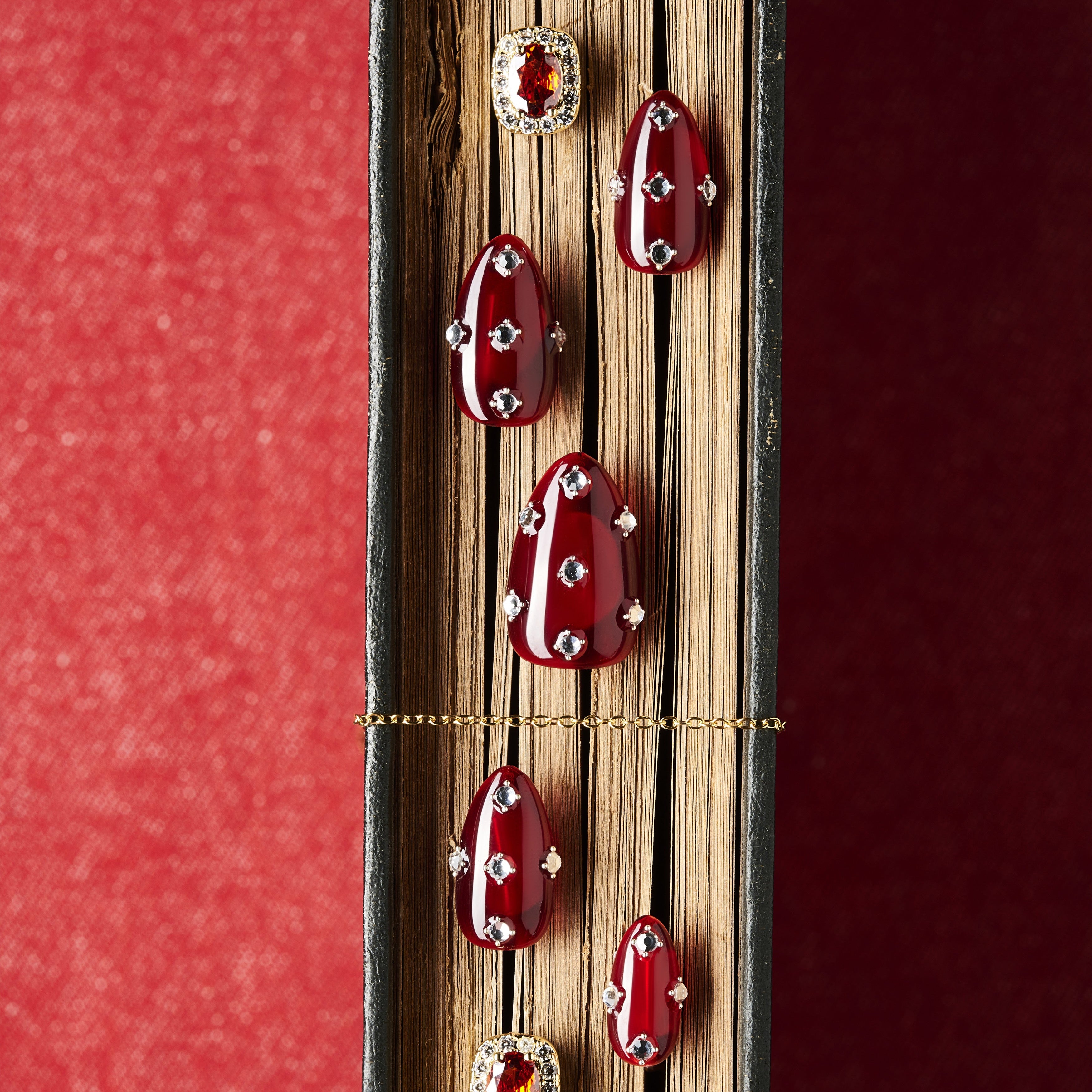Short burgundy press on nails with crystal detailing. Reusable elegant nail art set.