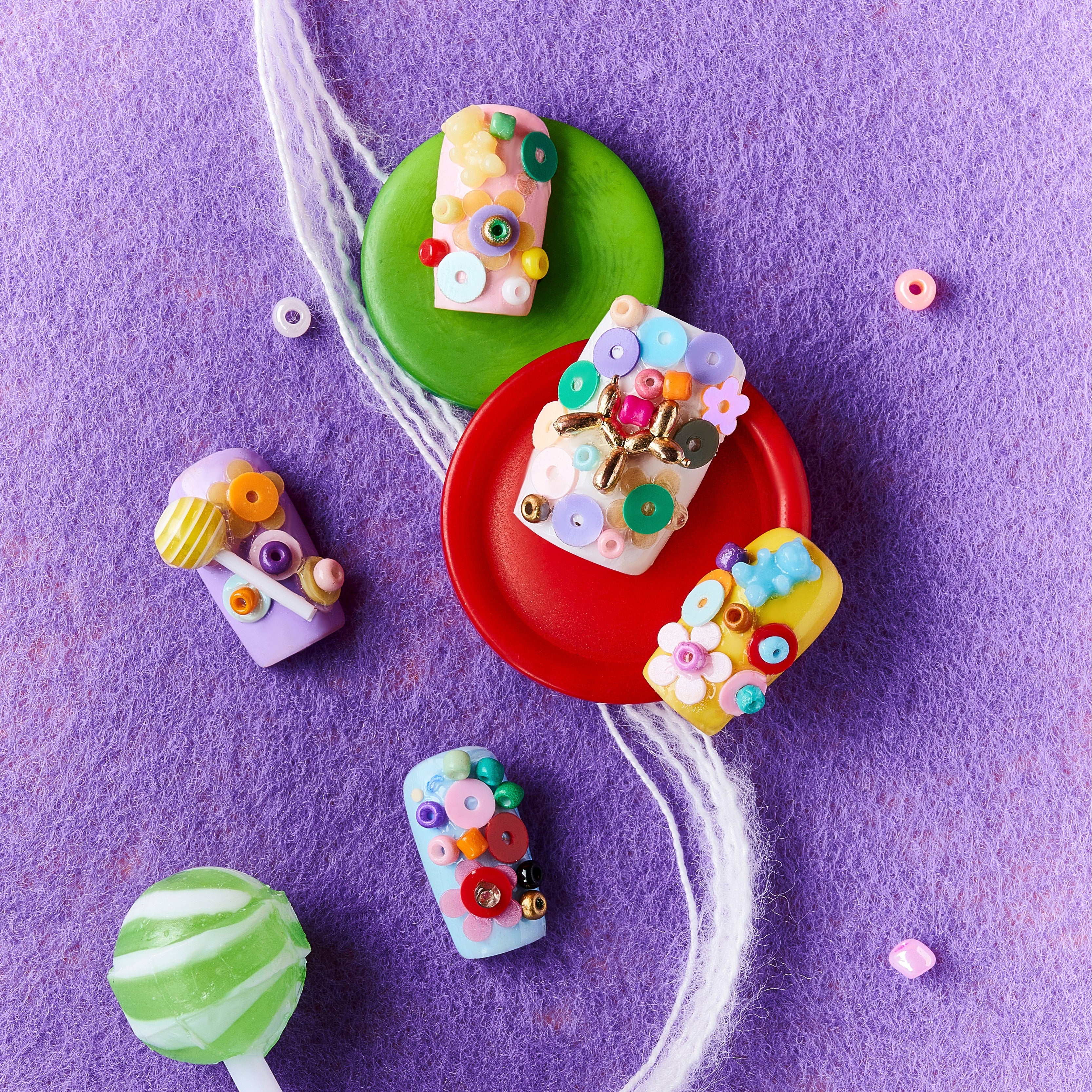 3D candy-inspired press on nails with beads and lollipop accents. Playful handmade nail set.