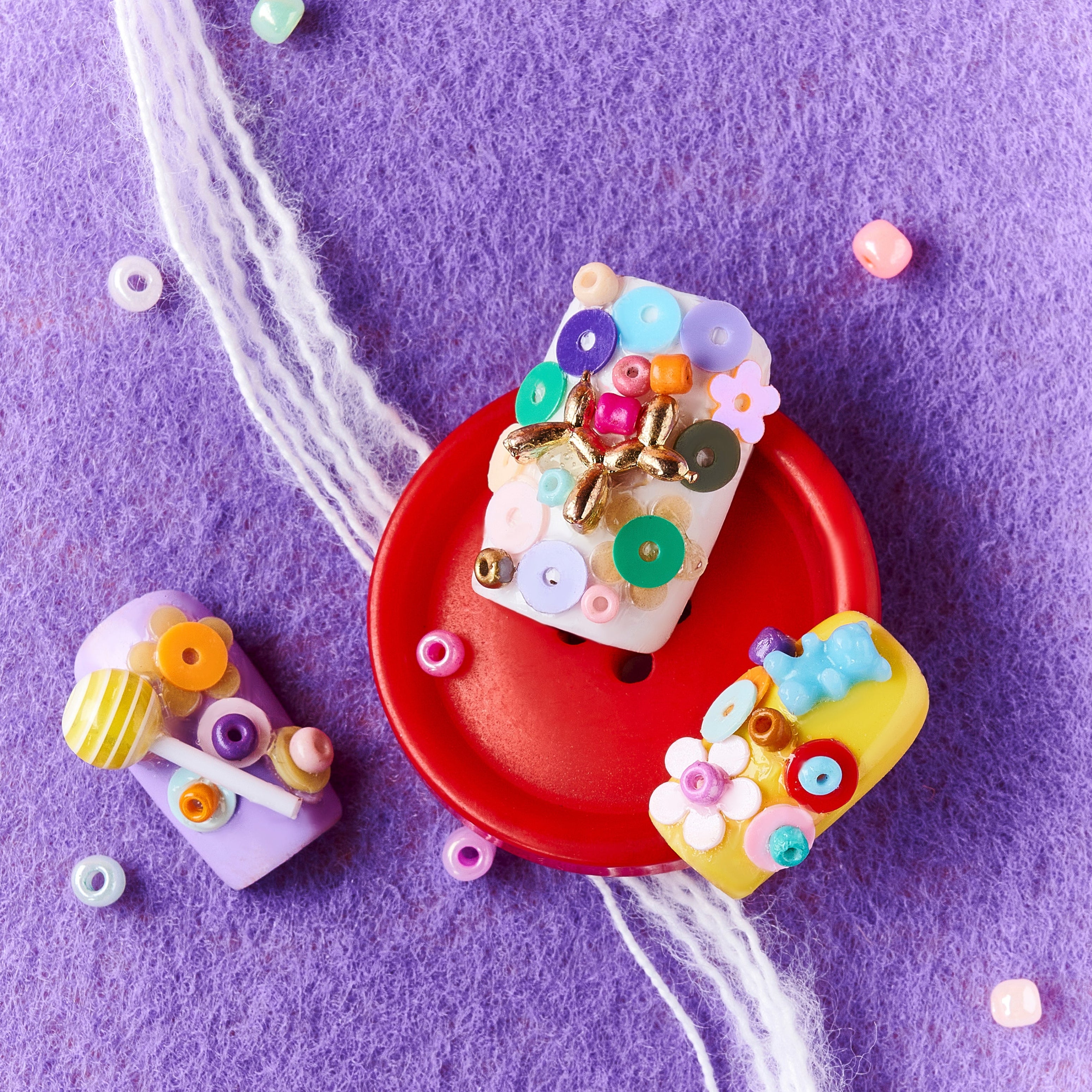 3D candy-inspired press on nails with beads and lollipop accents. Playful handmade nail set.