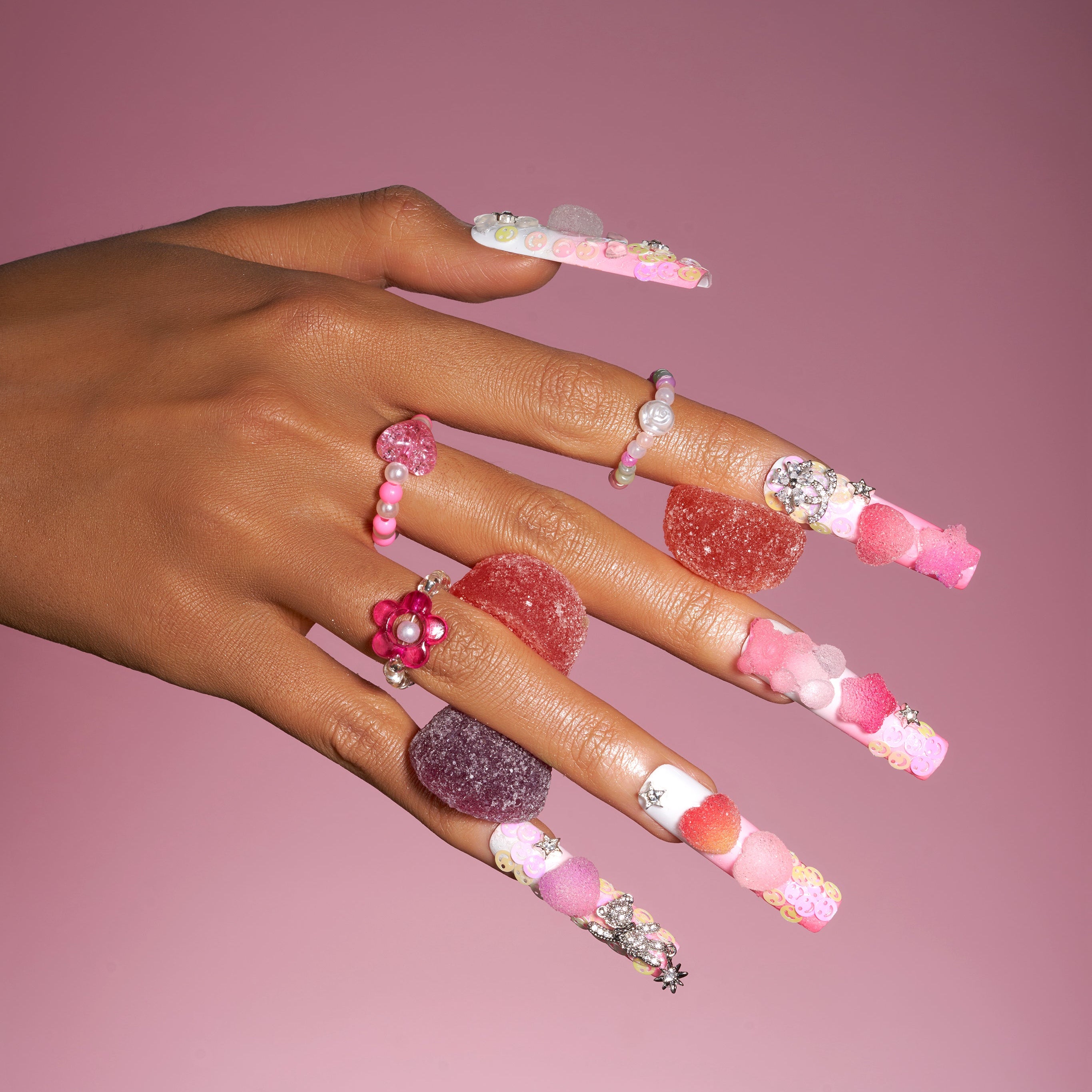 Playful 3D gummy bear press on nails with sugar heart accents and charms. Y2K inspired and reusable.