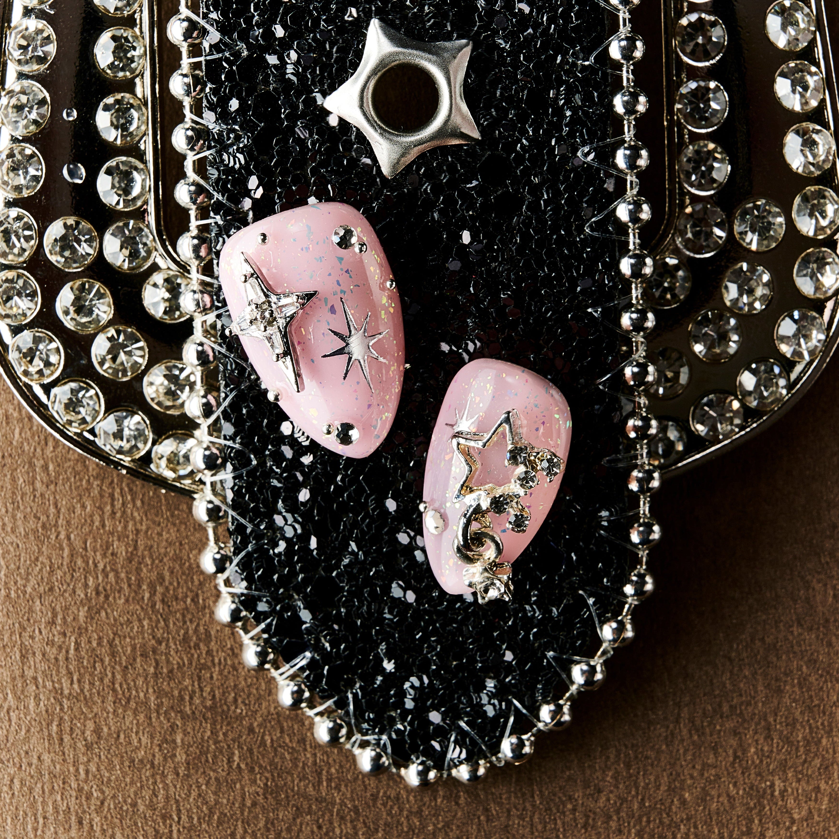 Dreamy pink glitter press on nails with star charms and crystal details. Soft glam and reusable.