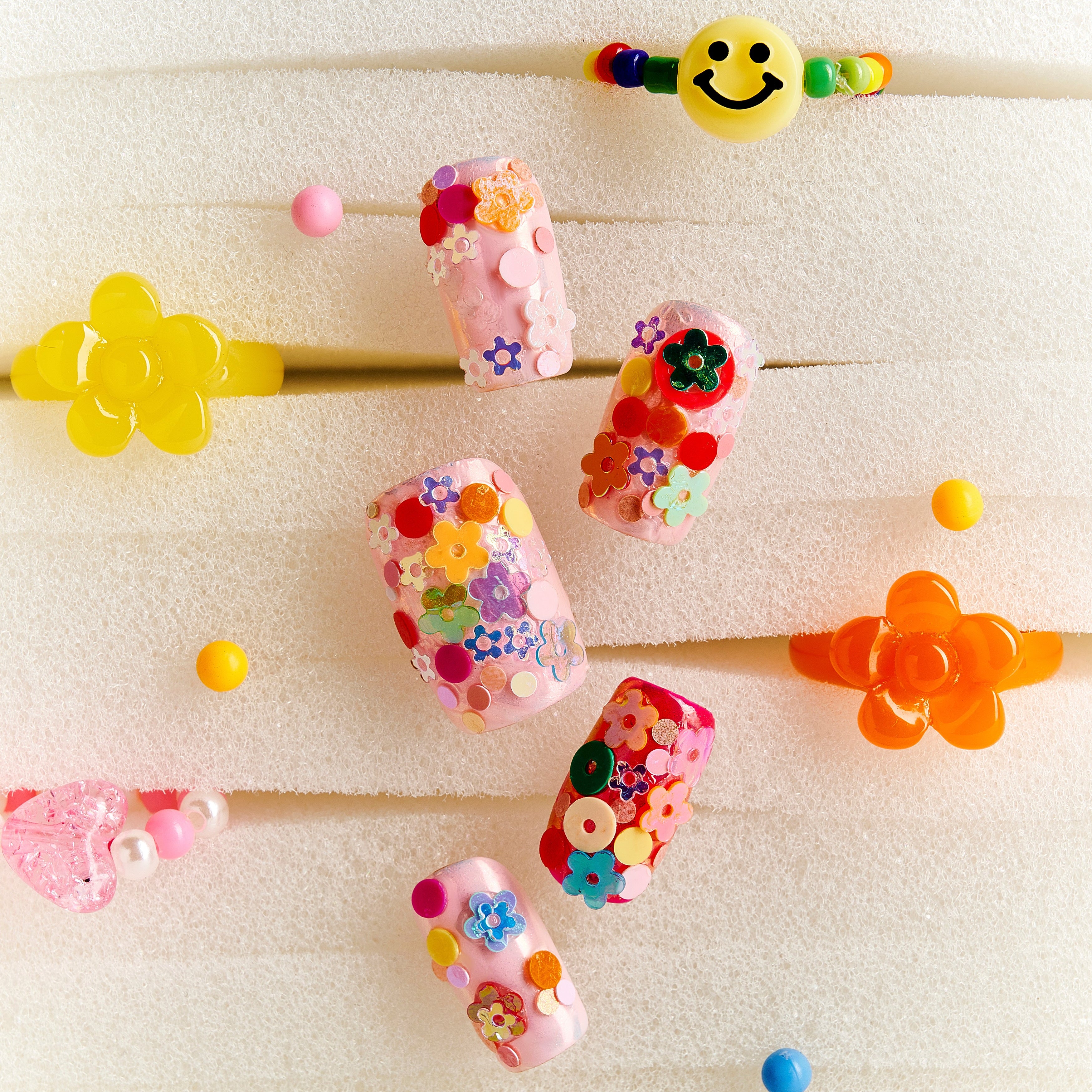 Colorful floral press on nails featuring 3D flower embellishments. Bold, fun and reusable nail set.