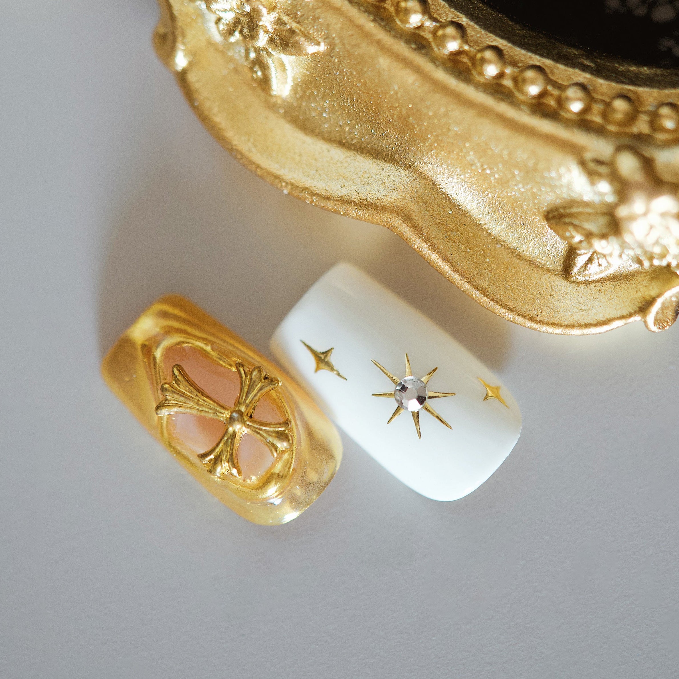 Nude French press on nails with bold crystal embellishments. Elegant sparkle and reusable luxury design.