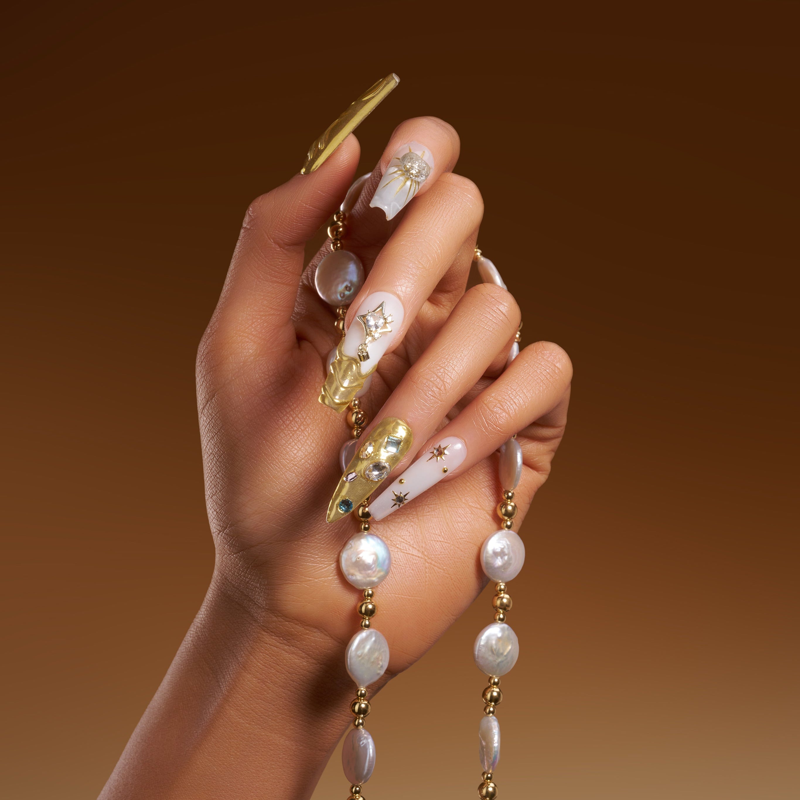 Luxury gold chrome press on nails with crystal details. High shine, sculpted texture and reusable glam design.
