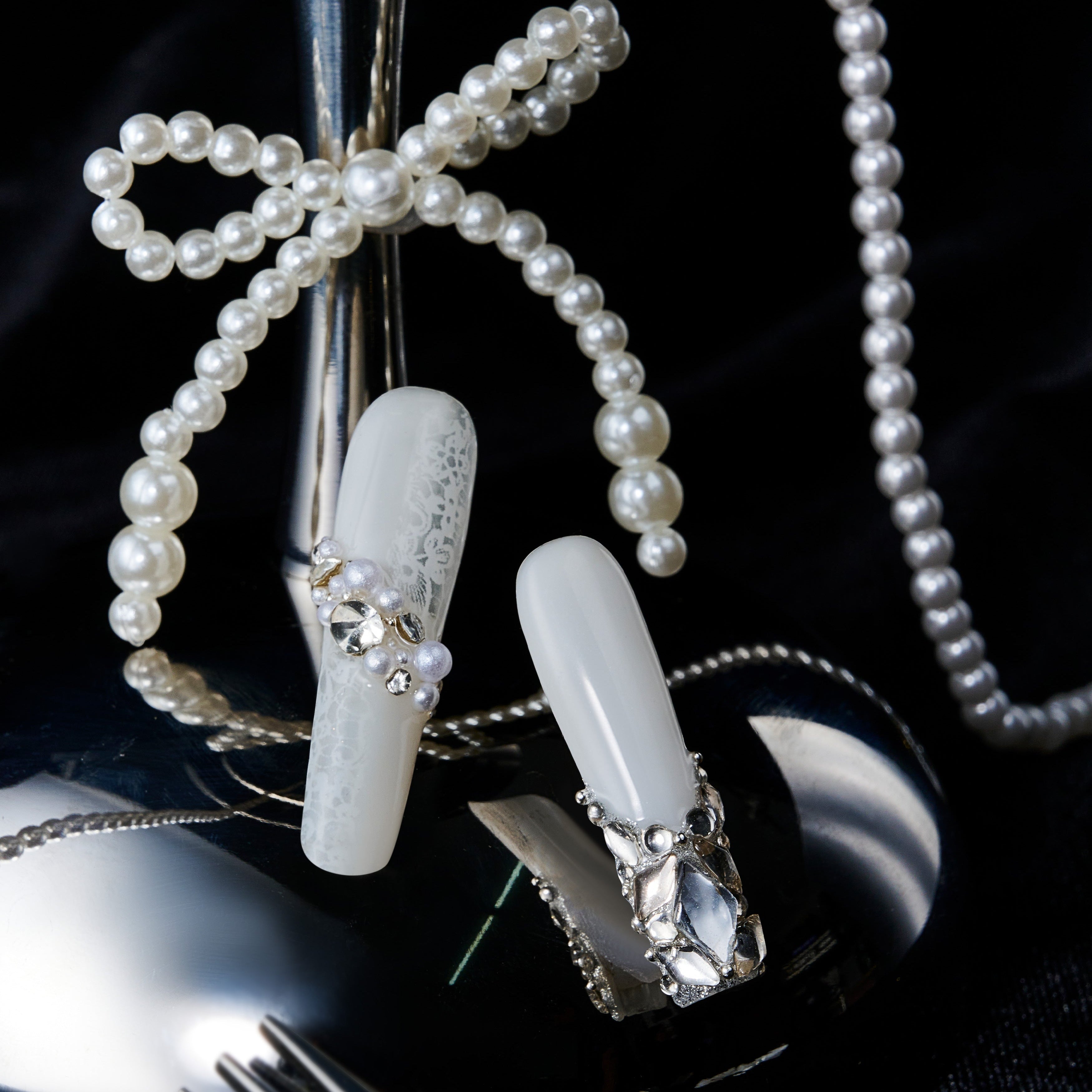 Romantic pink press on nails with crystal heart accents. Glossy finish and reusable salon-quality design.