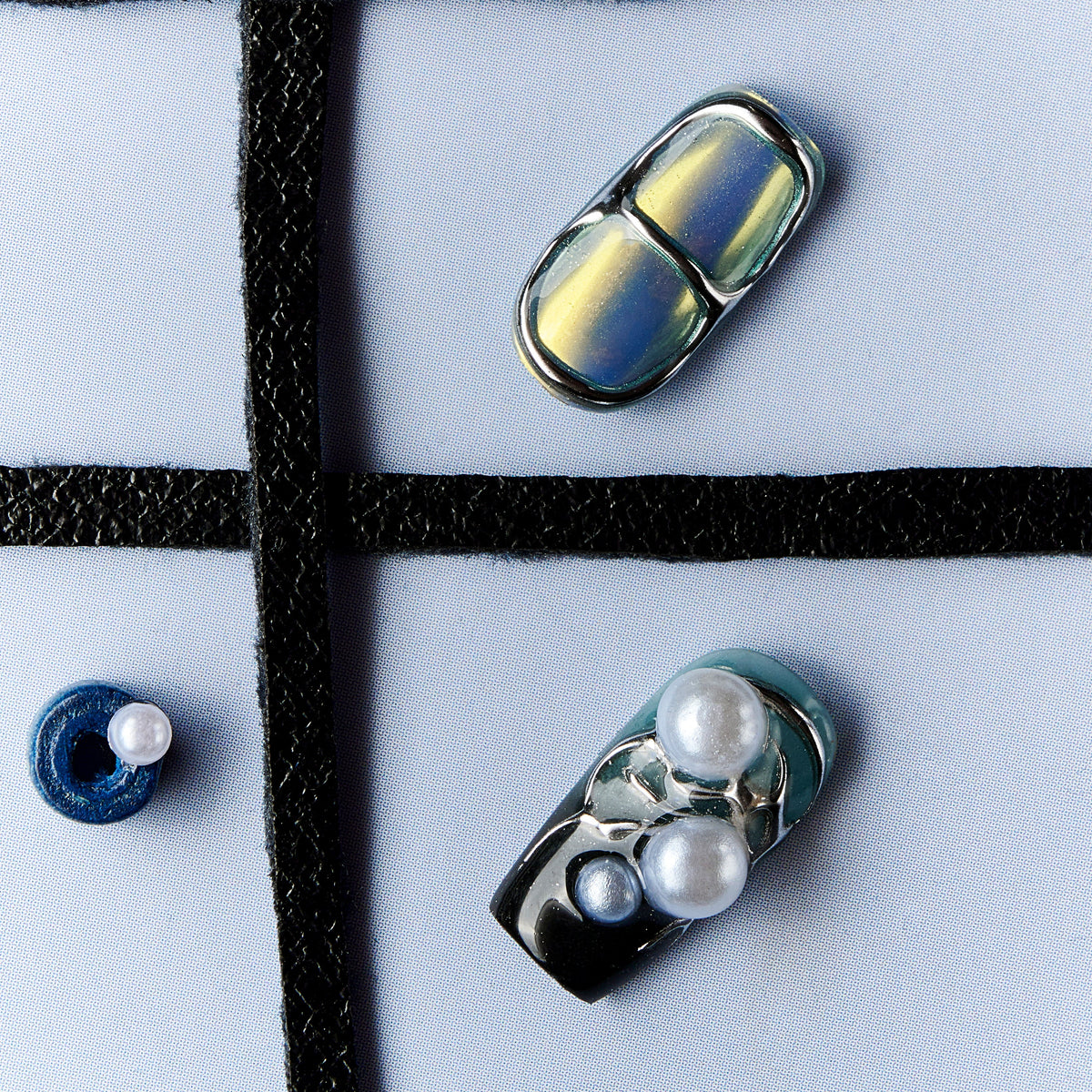 Cyber-style press on nails with chrome metallic finish, pearl embellishments and futuristic design.