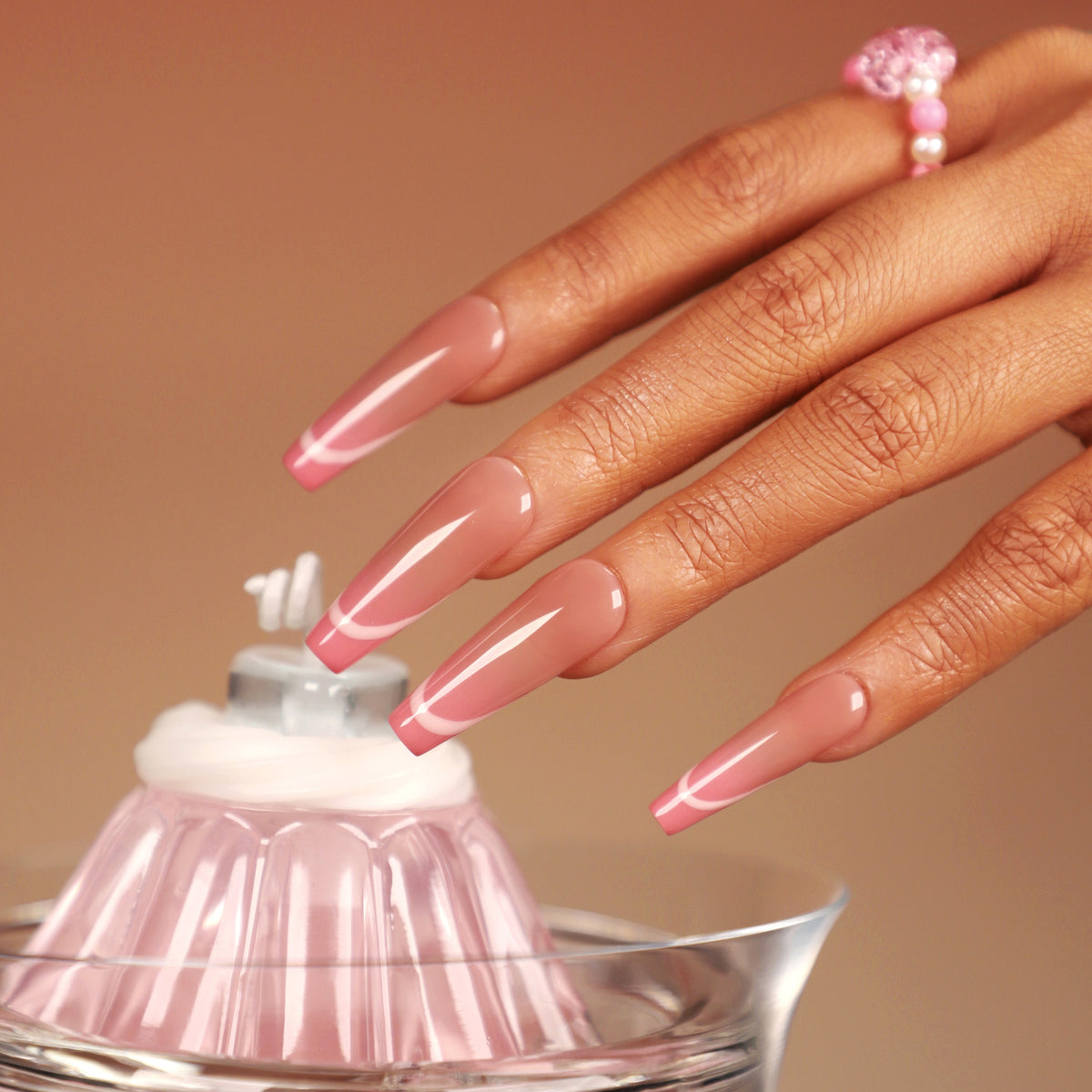 Neon pink outline press on nails with soft nude base, long glossy shape, reusable salon-quality false nails.