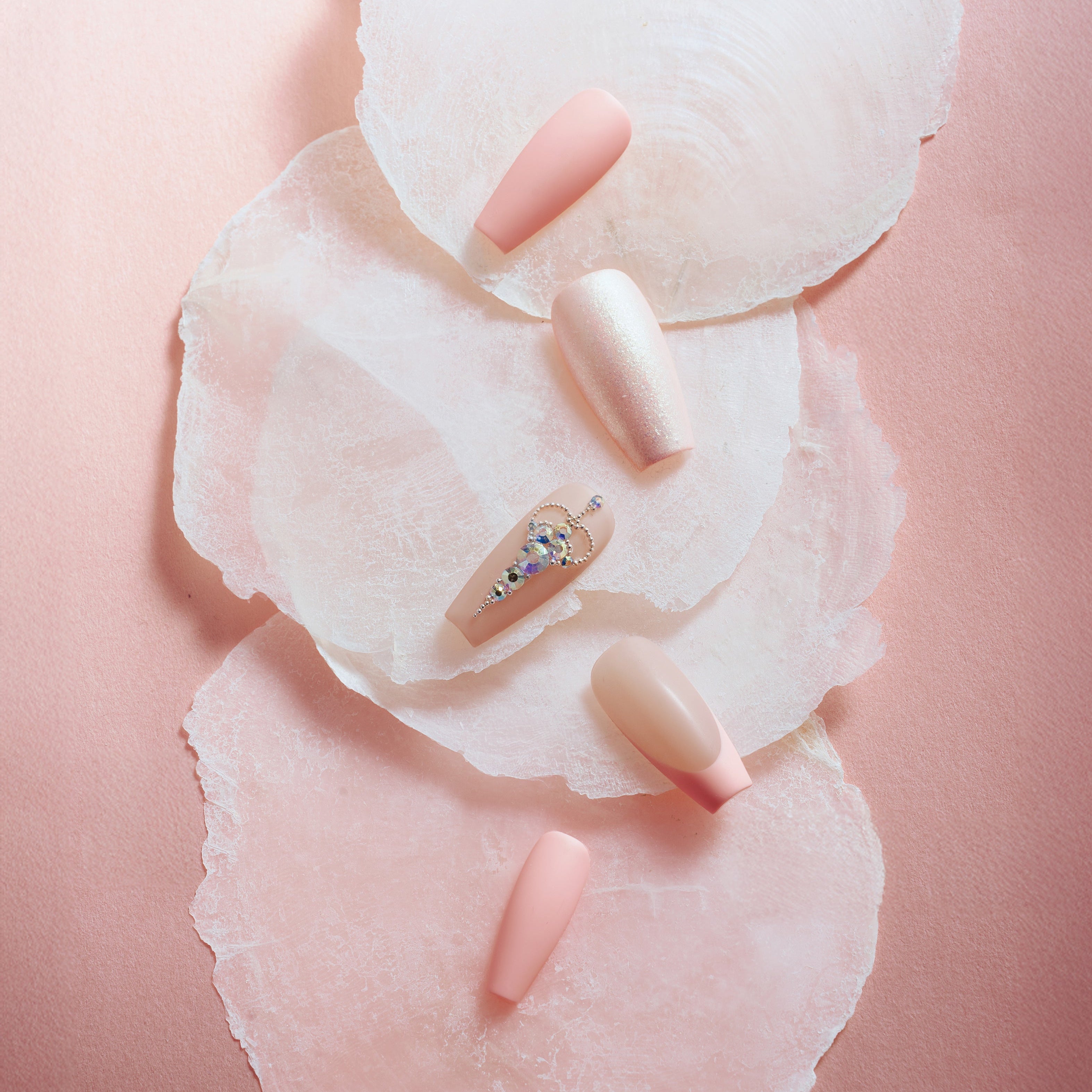 Pink sparkle elegance press on nails with shimmer glitter, nude pink tones, and rhinestone accent nail.