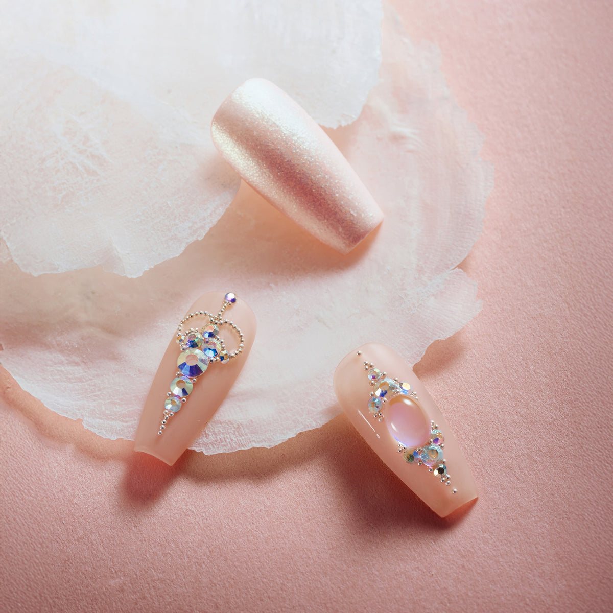 Pink sparkle elegance press on nails with shimmer glitter, nude pink tones, and rhinestone accent nail.