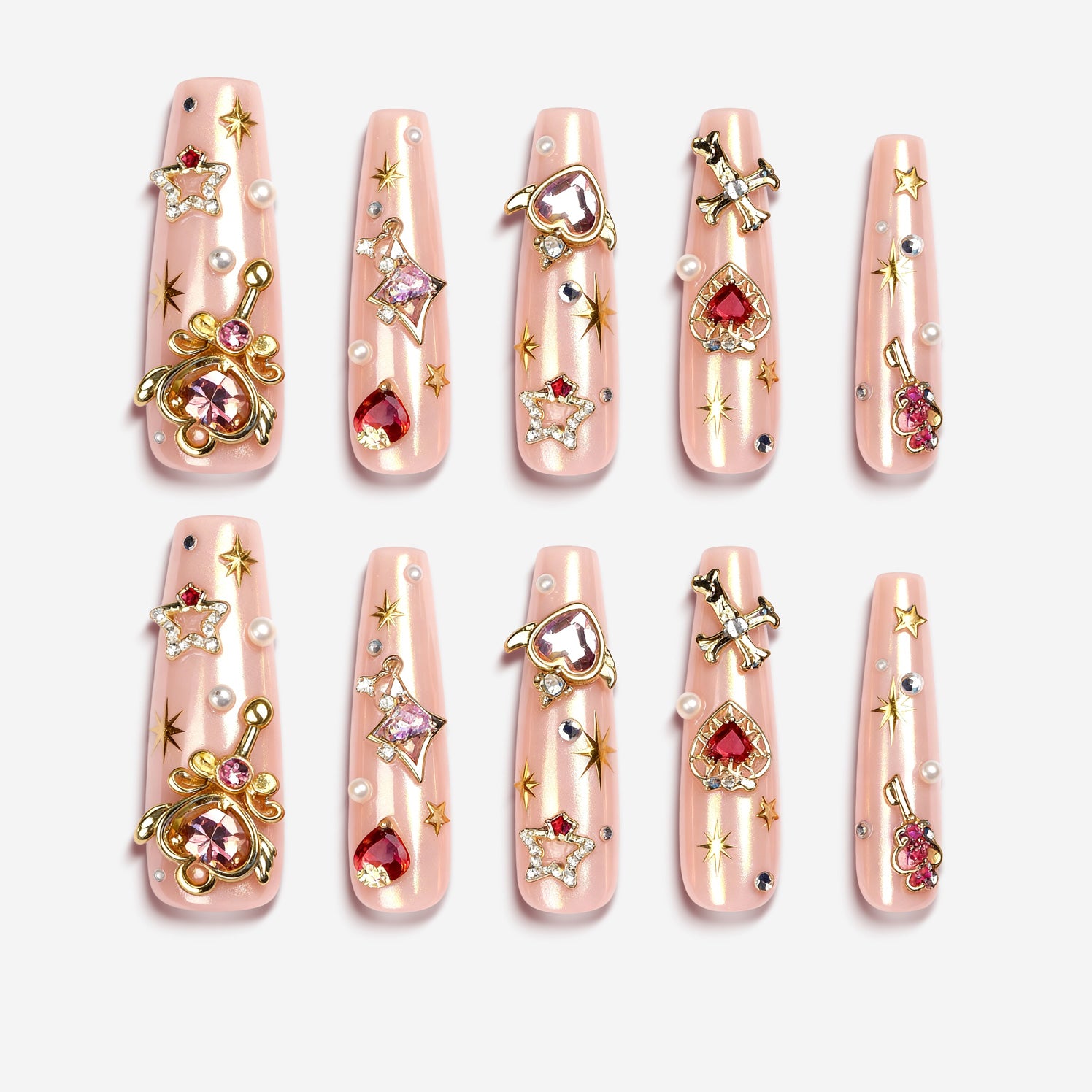 Princess Secret press on nails with gold charms, red gems, pearls, and glossy nude-pink base.
