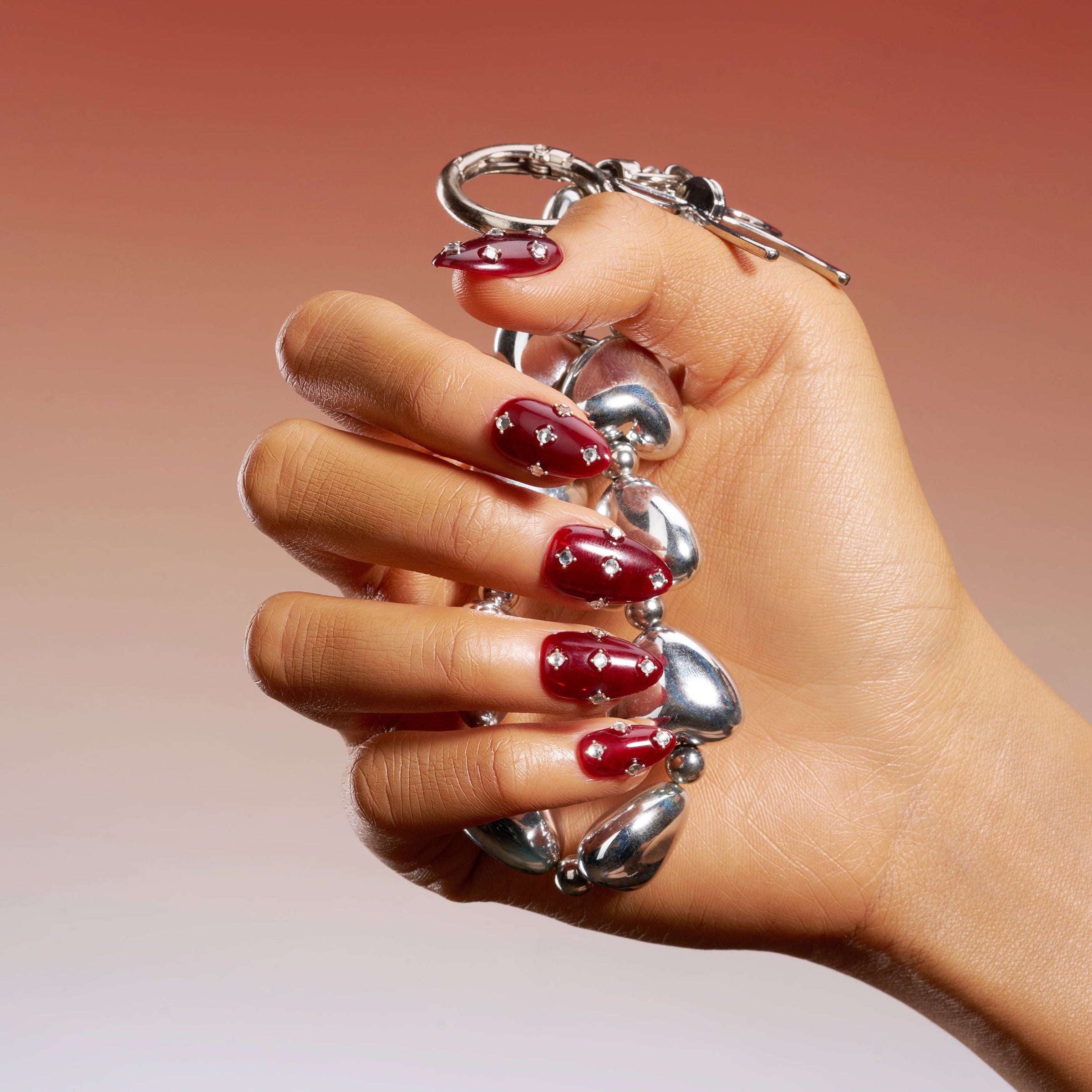 Short burgundy press on nails with crystal detailing. Reusable elegant nail art set.