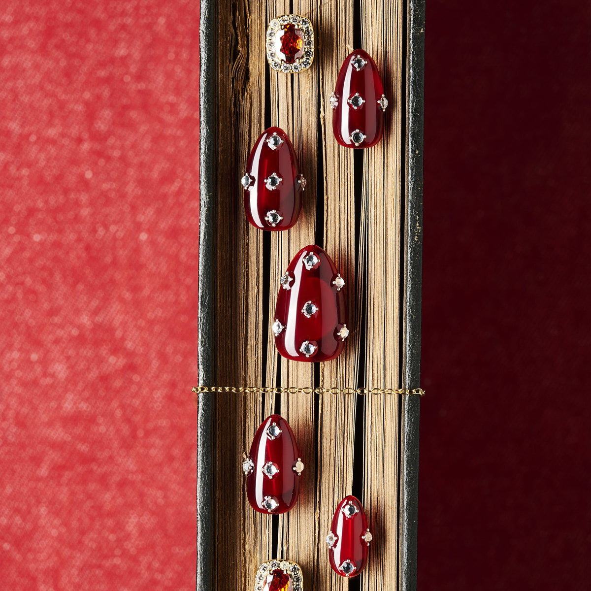 Short burgundy press on nails with crystal detailing. Reusable elegant nail art set.