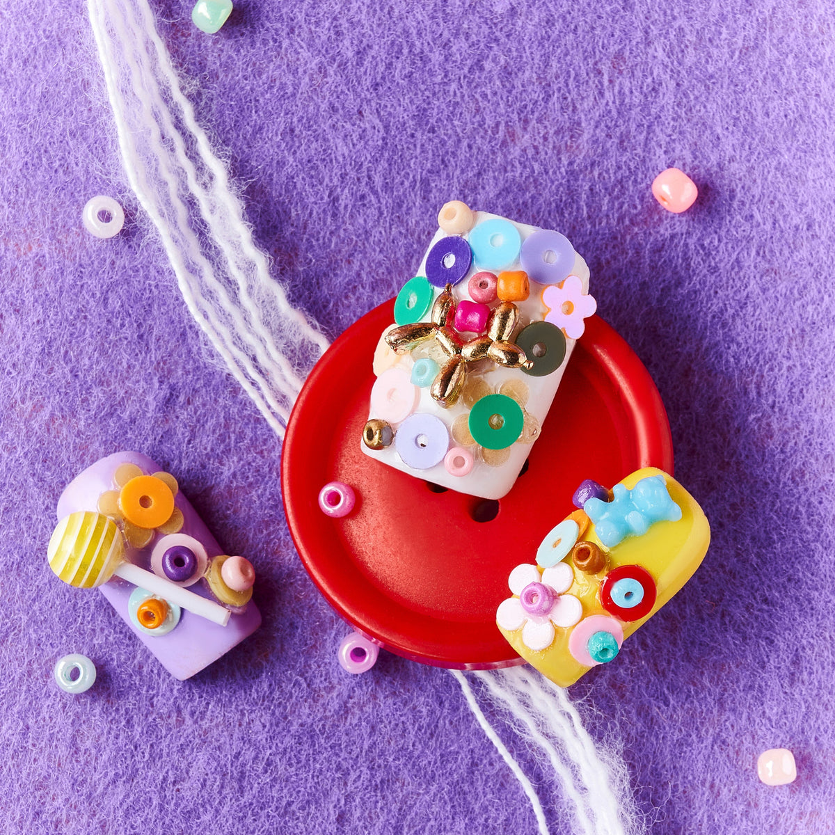 3D candy-inspired press on nails with beads and lollipop accents. Playful handmade nail set.
