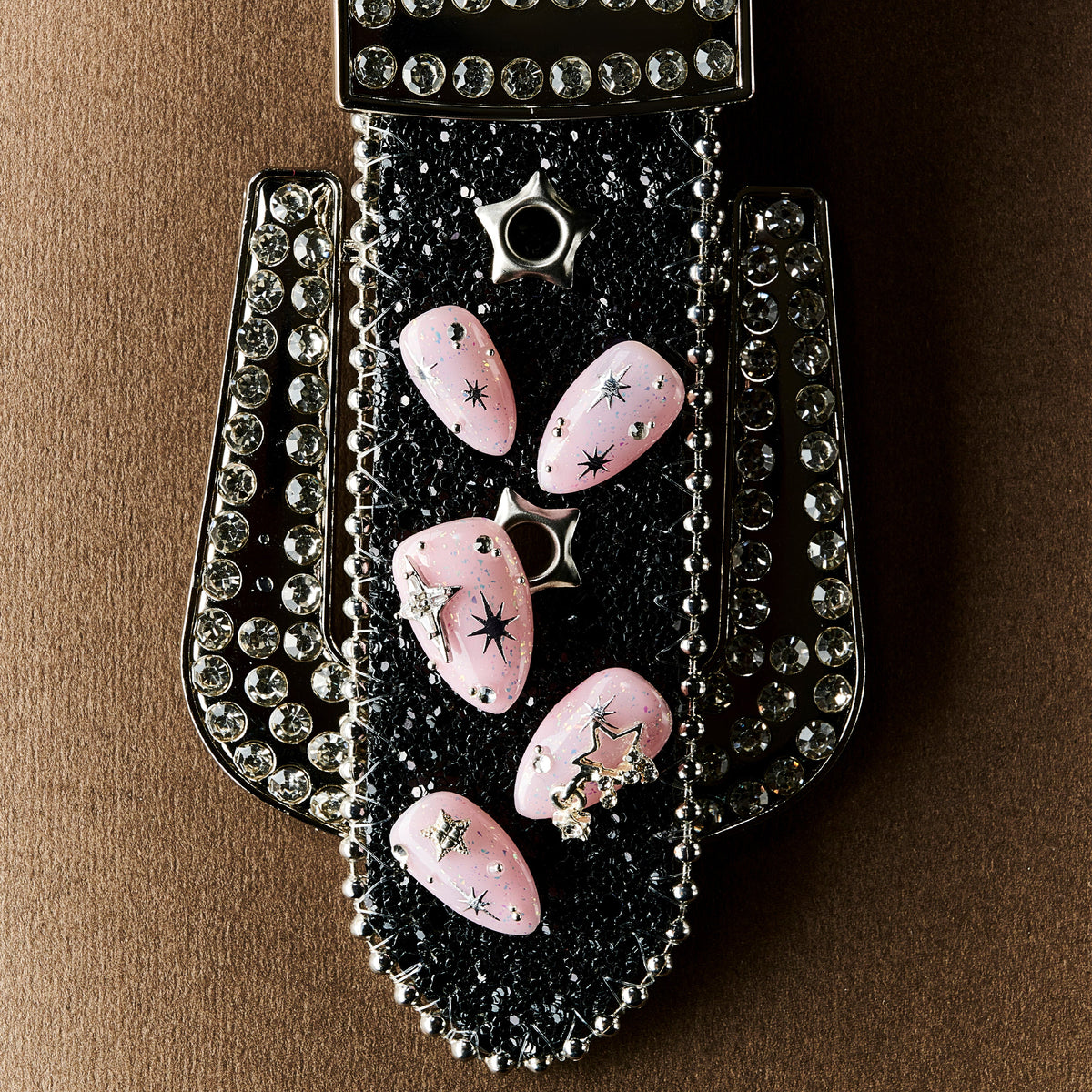 Dreamy pink glitter press on nails with star charms and crystal details. Soft glam and reusable.