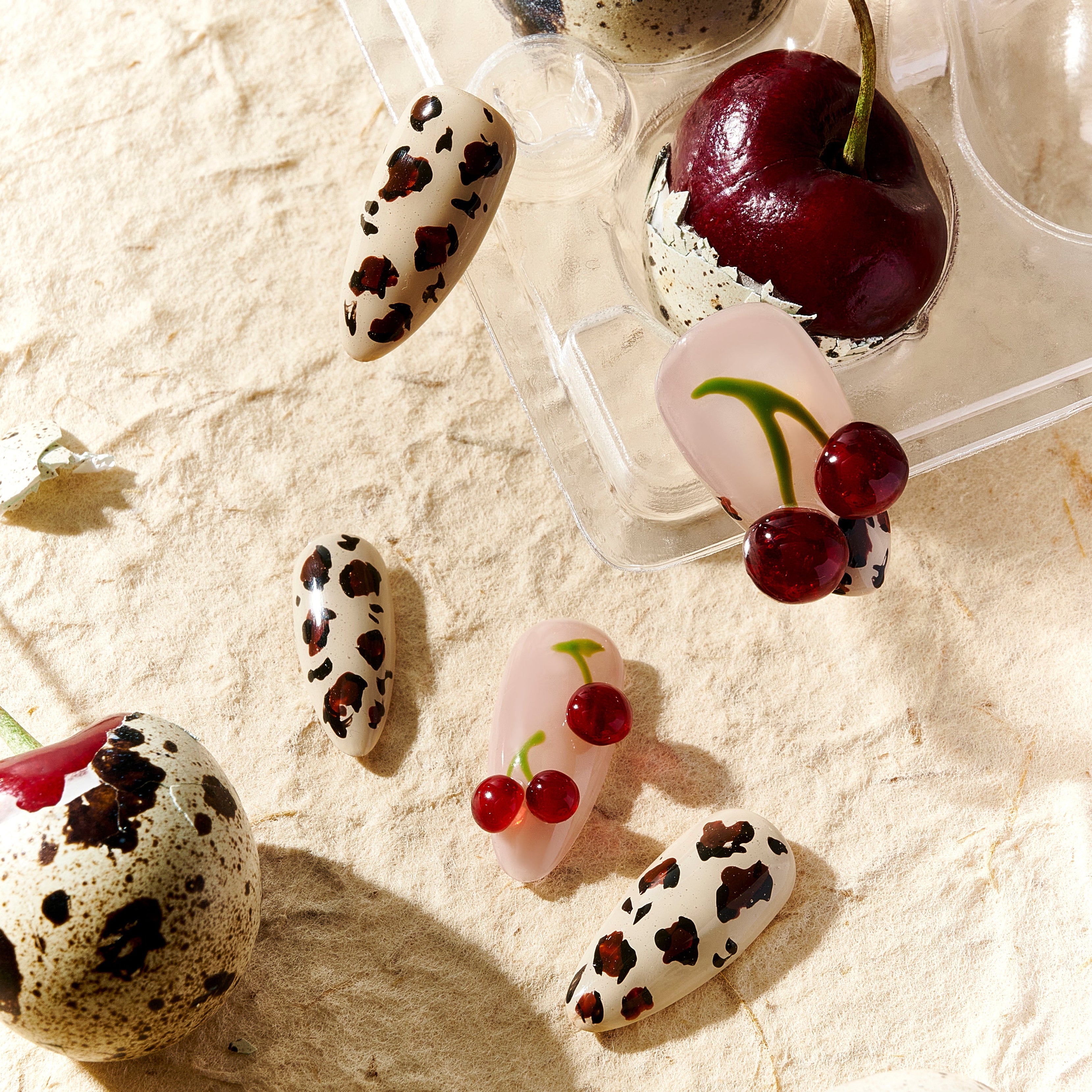 Almond press on nails with cherry art and brown leopard print on nude and pink base