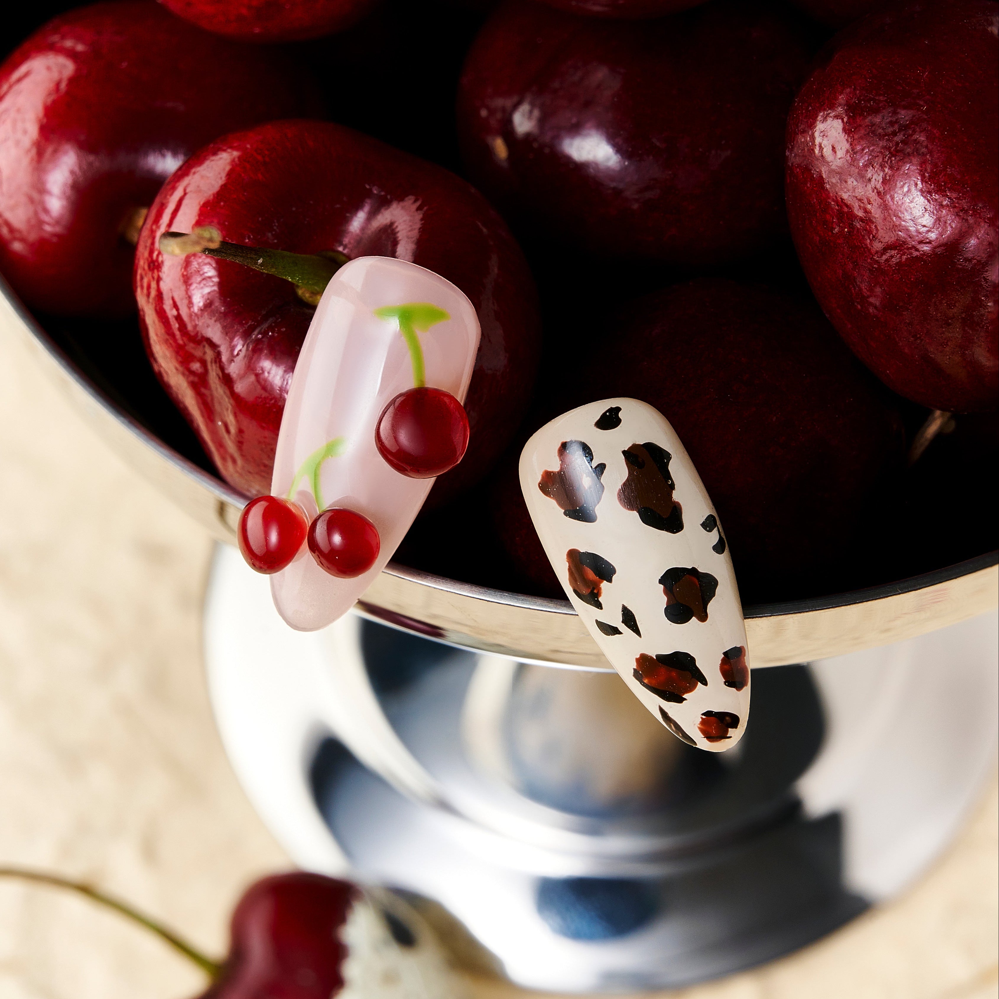 Almond press on nails with cherry art and brown leopard print on nude and pink base