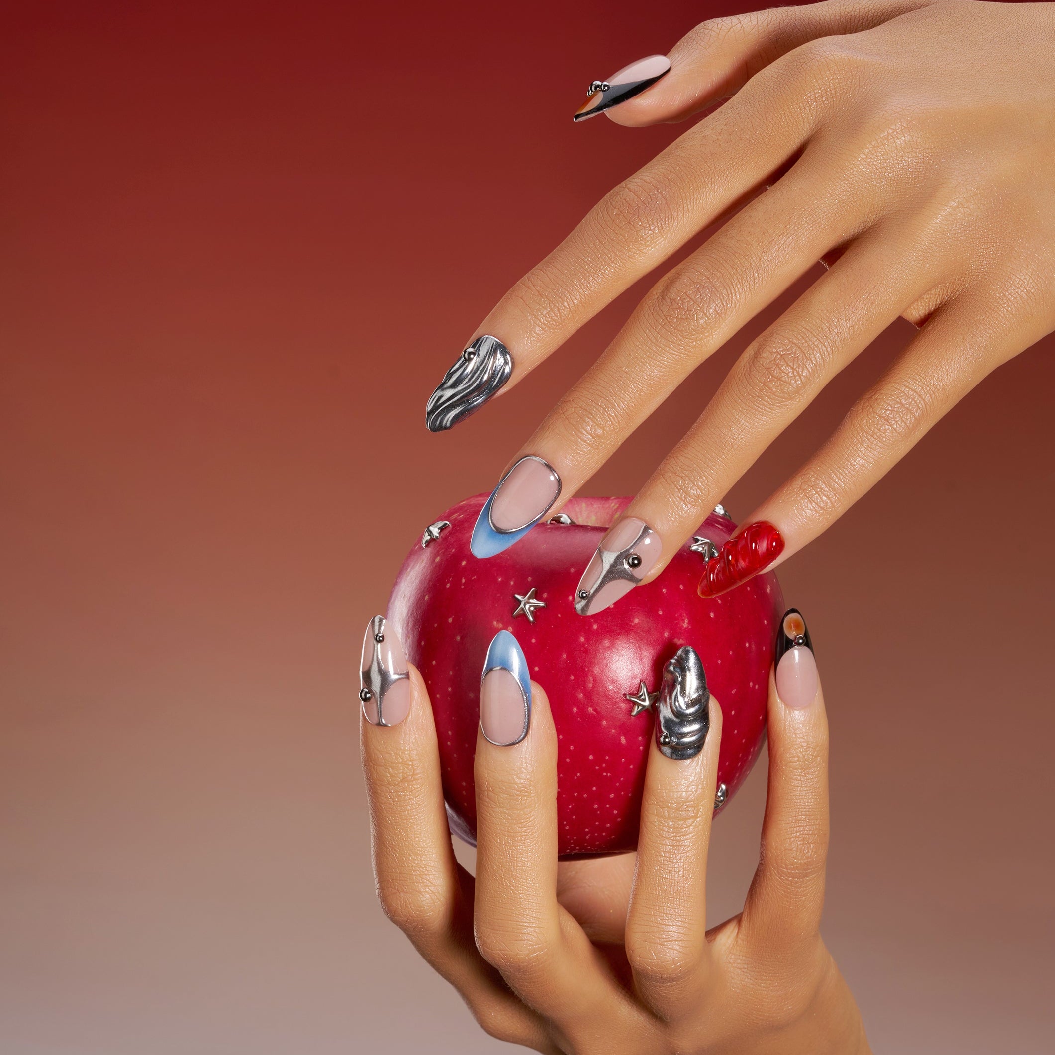 Modern almond press on nails with silver chrome accents and cool nude base. Sleek, glossy and reusable.