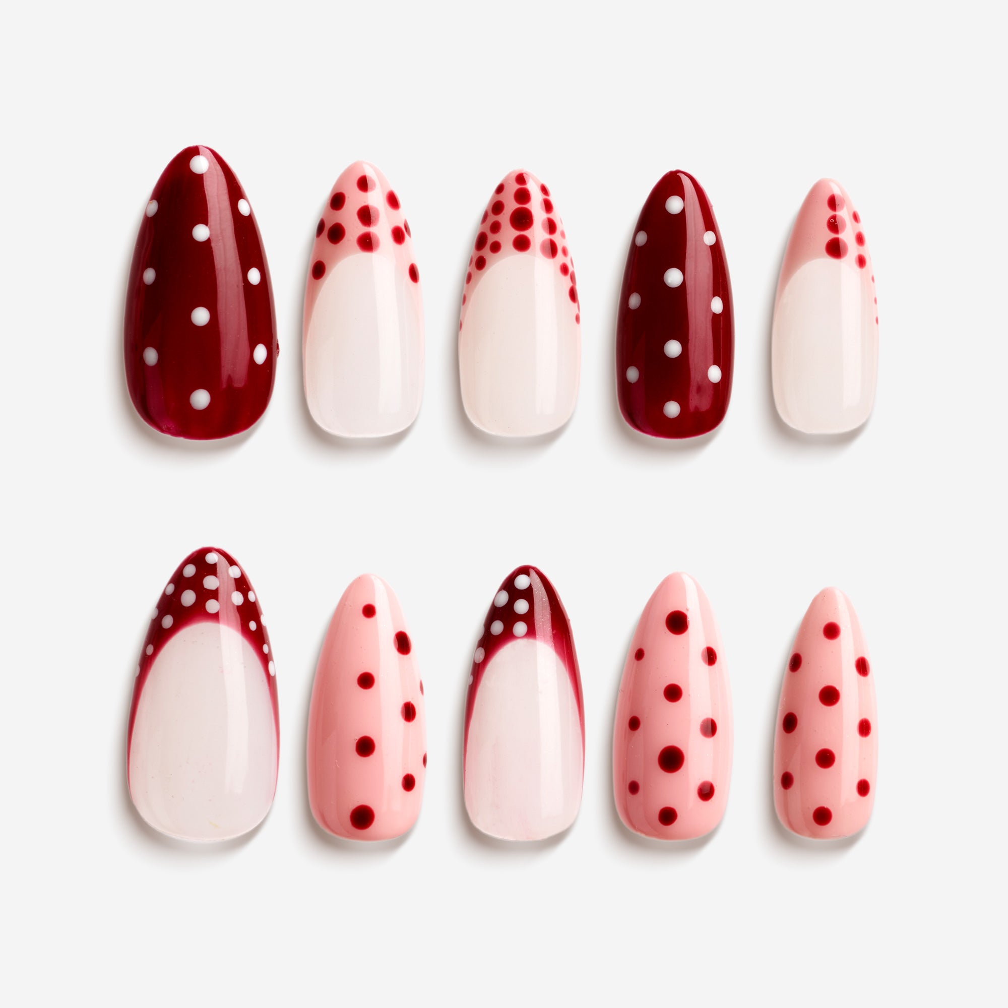 Pink and brown press on nails with polka dots, stripes, and bow details