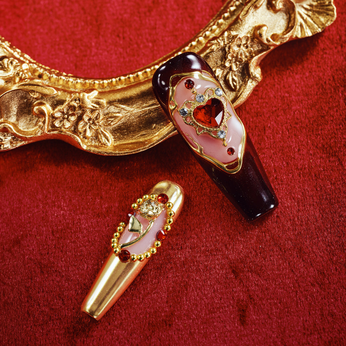 Burgundy press on nails with gold detailing and heart gemstone accents. Romantic, bold and reusable.