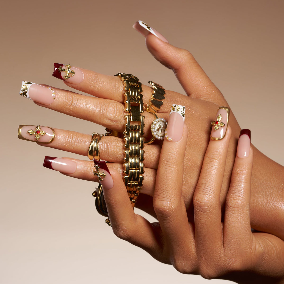 Elegant nude press on nails with gold foil and cross embellishments. Reusable luxury nail set.