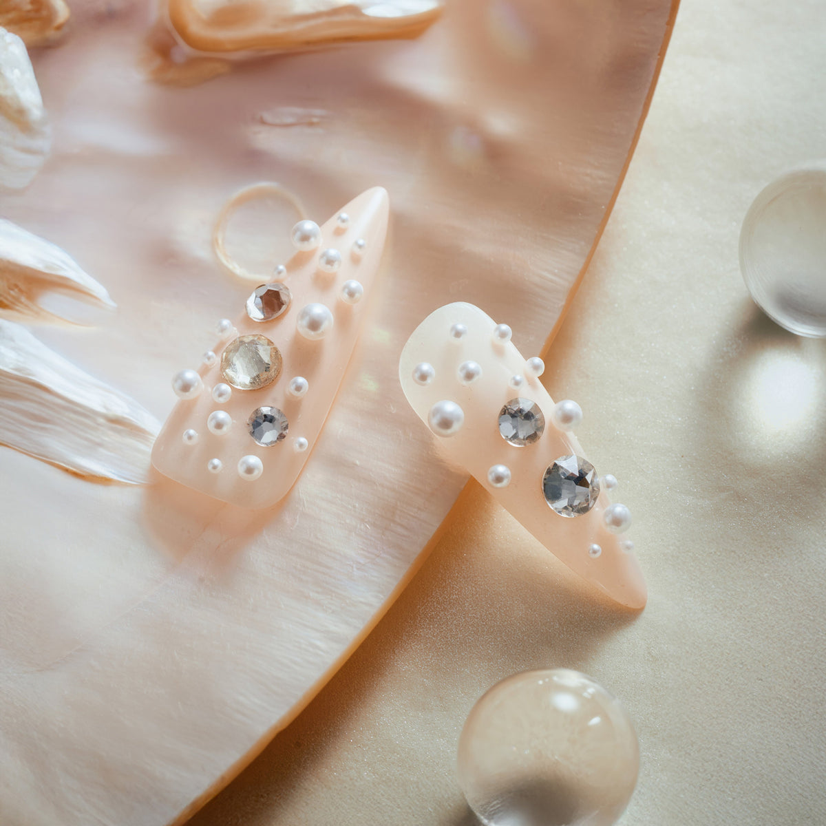 Nude press on nails with pearl and rhinestone clusters for soft luxury style