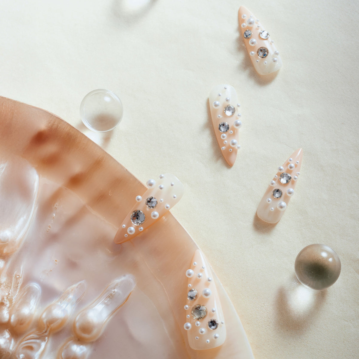Nude press on nails with pearl and rhinestone clusters for soft luxury style