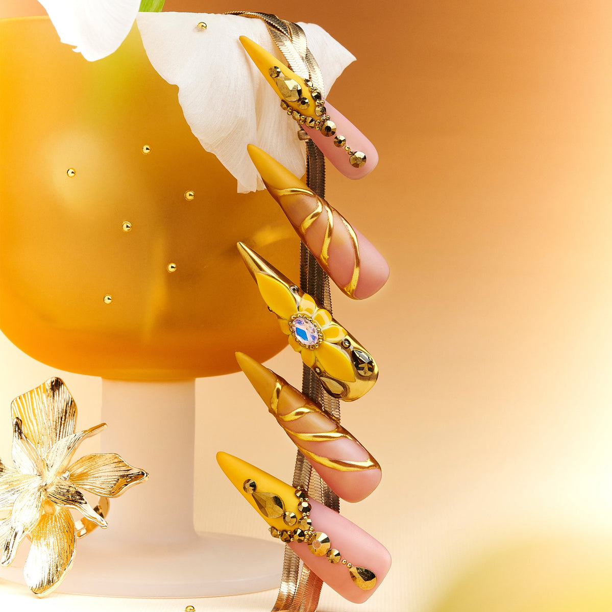 Luxury gold butterfly press on nails with gemstone accents. Dramatic stiletto shape and reusable salon finish.