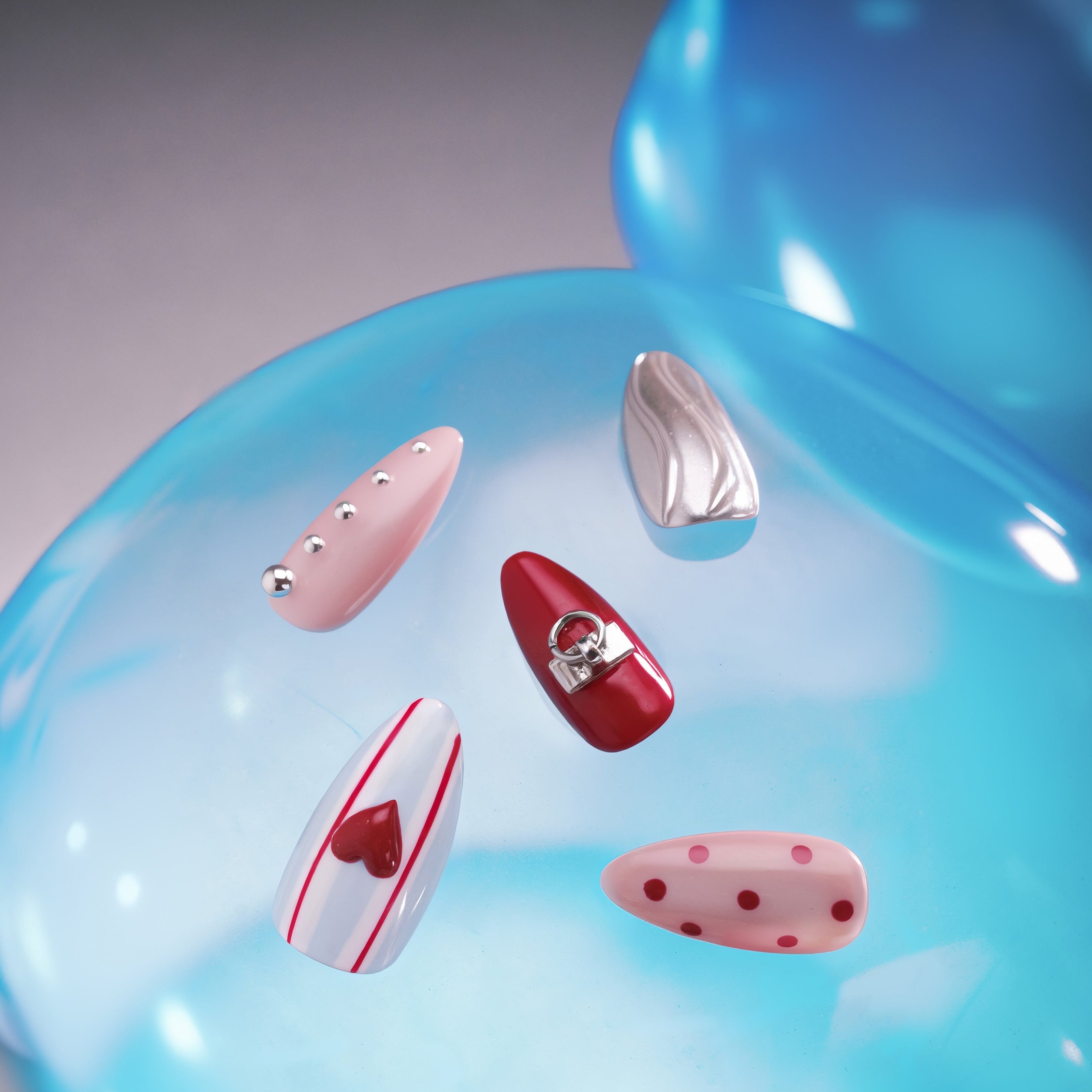 Modern heart press on nails with glossy red and metallic details. Trendy, reusable and eye-catching.