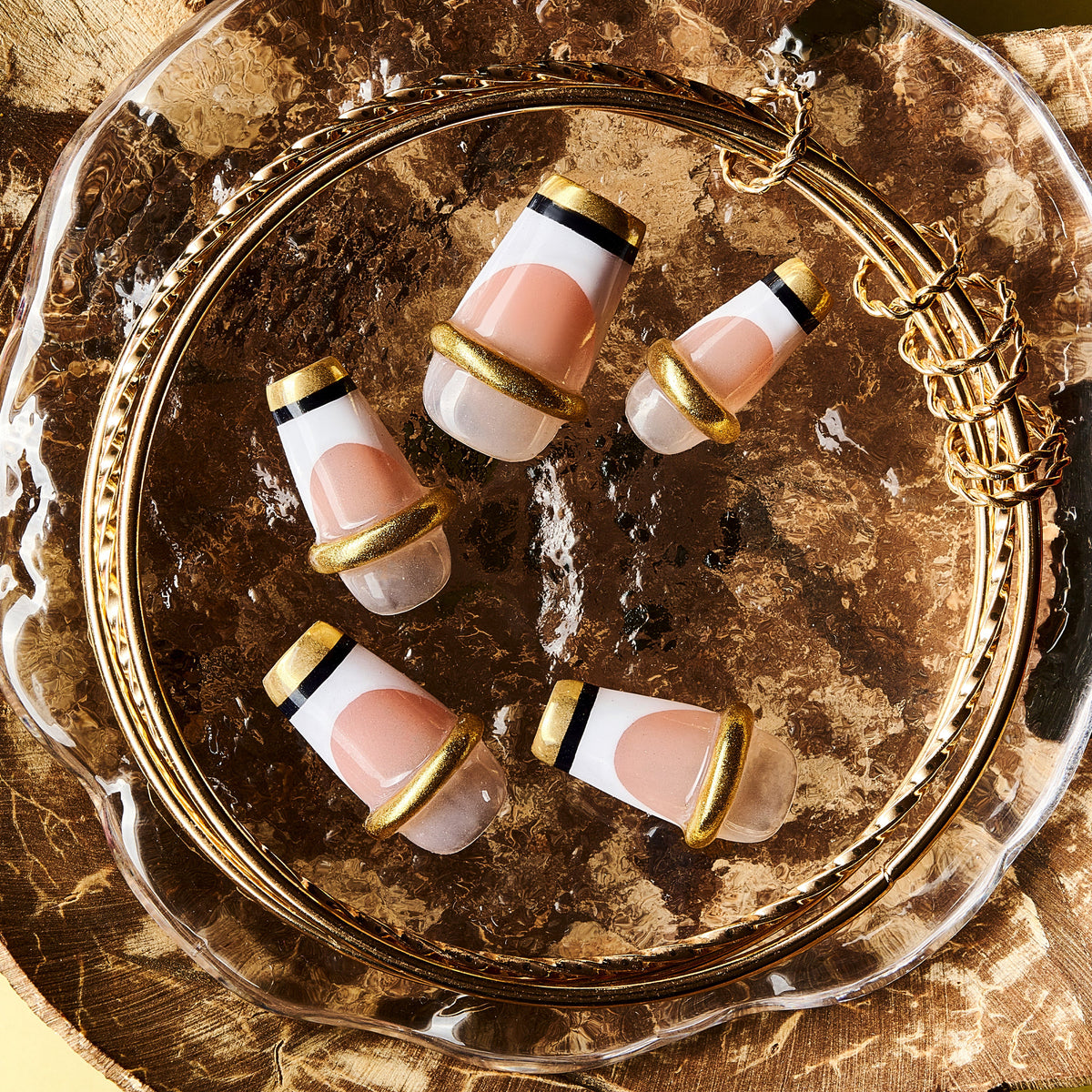 Nude Glow Trim press on nails with gold capsule-style French design