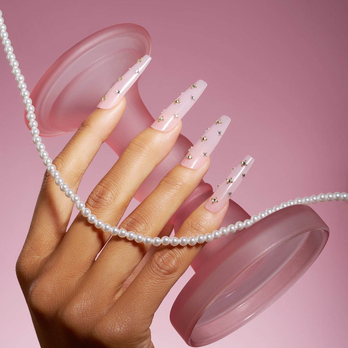 Elegant pink press on nails with crystal gem details. Glossy coffin shape, reusable and perfect for chic everyday glam.