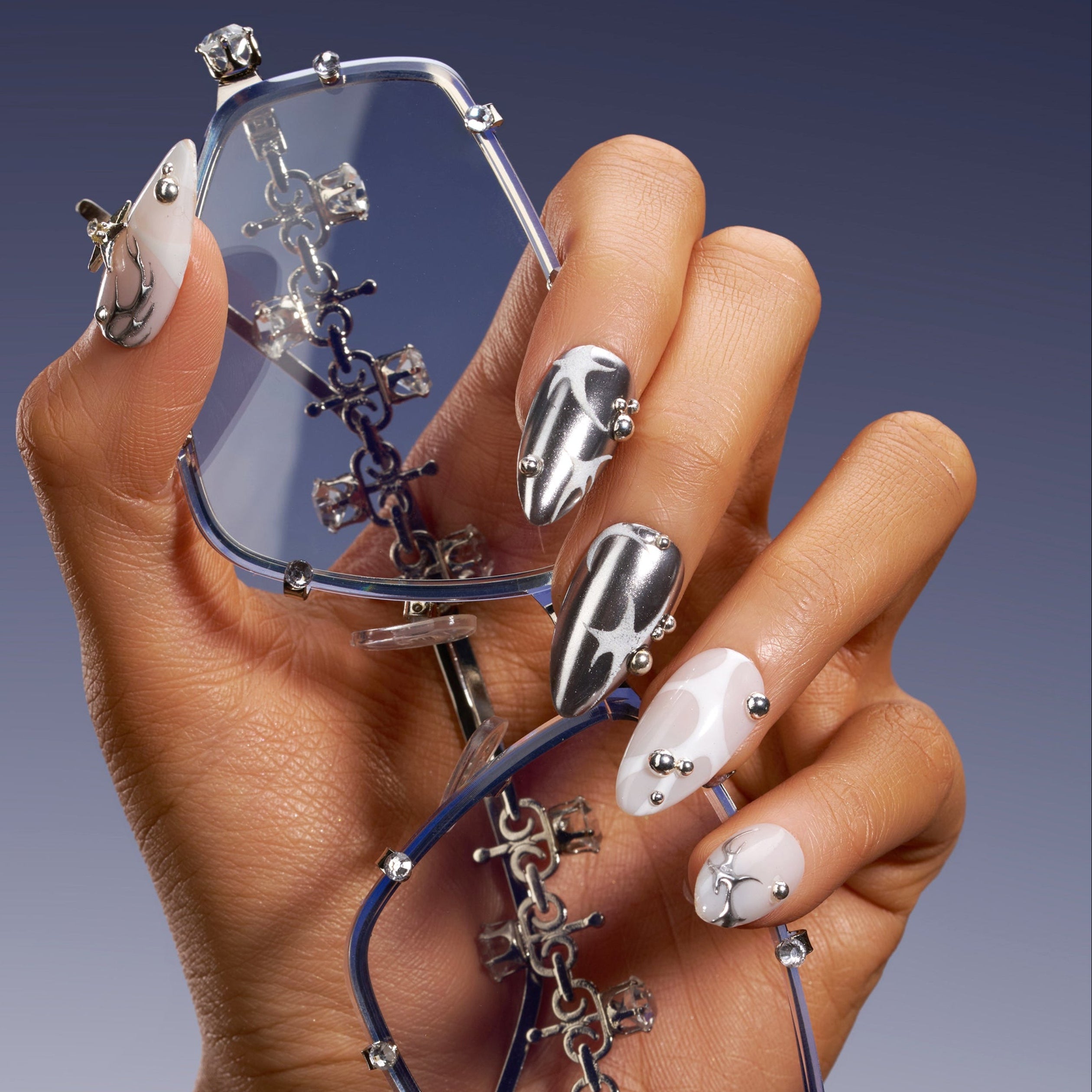 Silver Mystique metallic press on nails with abstract chrome textures.