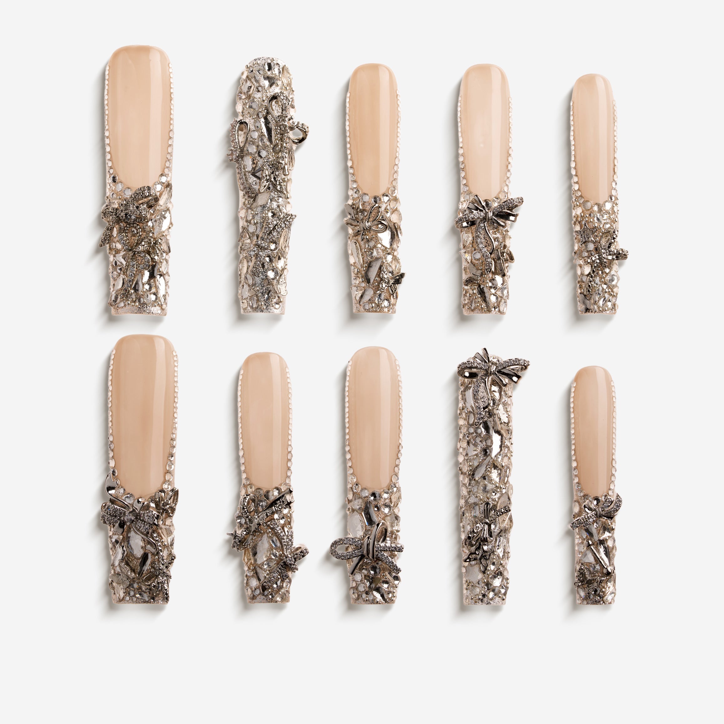 Silver Wing Shine long nude press on nails with heavy crystal embellishments.