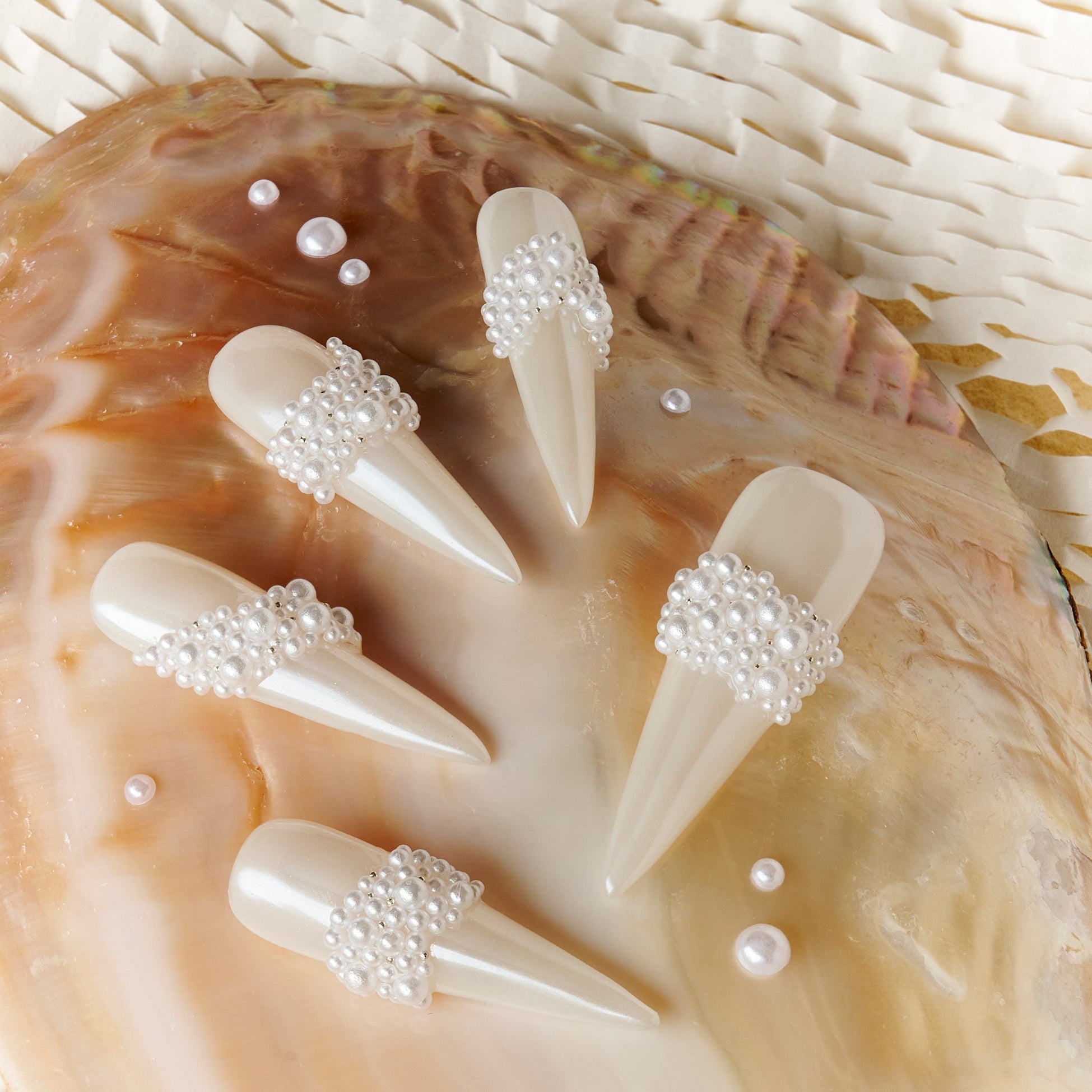 Starry Tips white stiletto press on nails decorated with pearl cluster accents.