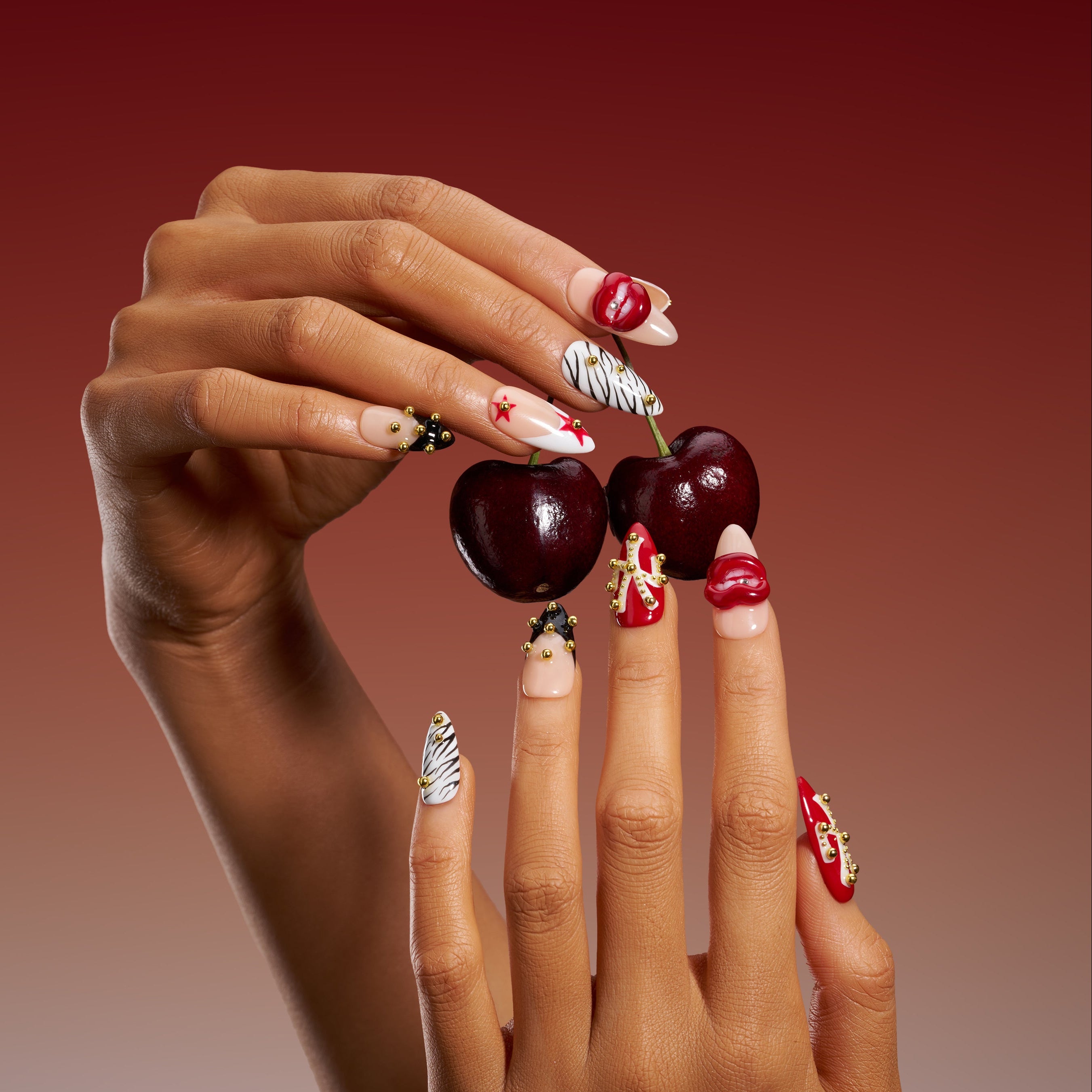 Artistic press on nails with sculpted red lips and studded details. Handmade reusable nail art set with bold style.