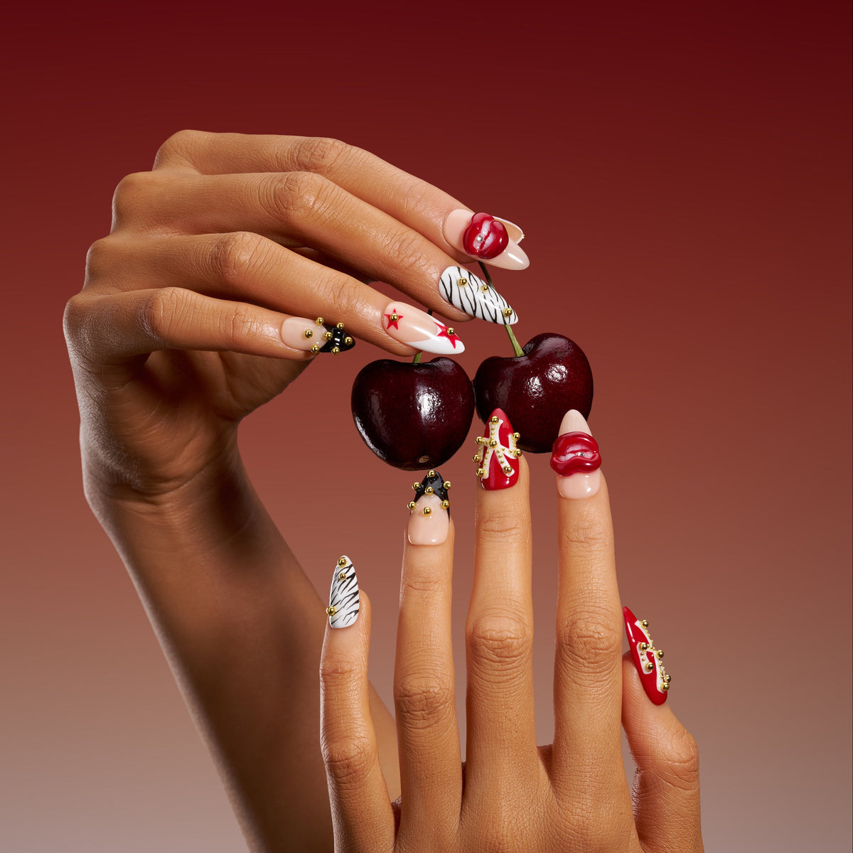 Artistic press on nails with sculpted red lips and studded details. Handmade reusable nail art set with bold style.