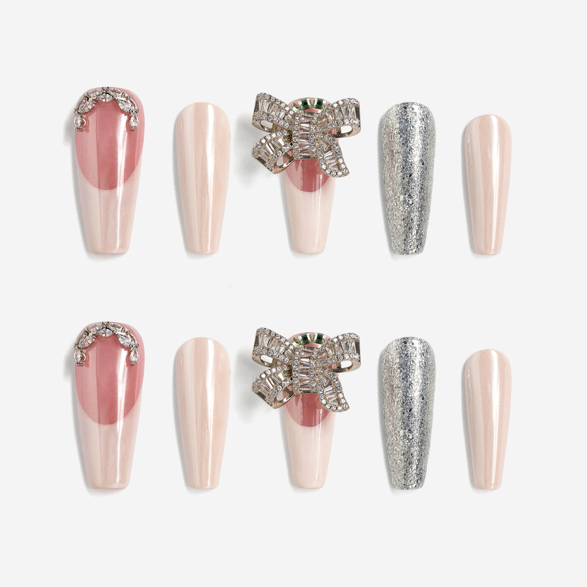 Pink and nude press on nails with silver glitter, rhinestones, and crystal bow charm